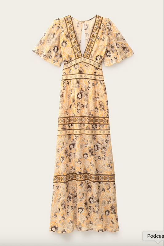 Vestido con escote en V y espalda descubierta y manga corta con estampado amarillo, crudo y naranja. Para alquiler en Barcelona.